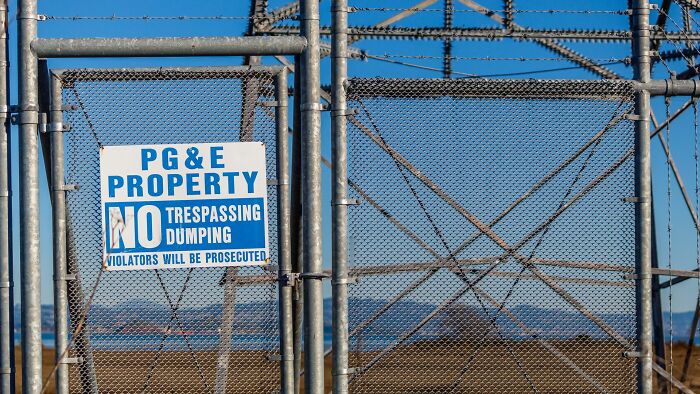 A sign reading PG&E Property on a fence, representing companies people refuse to support.