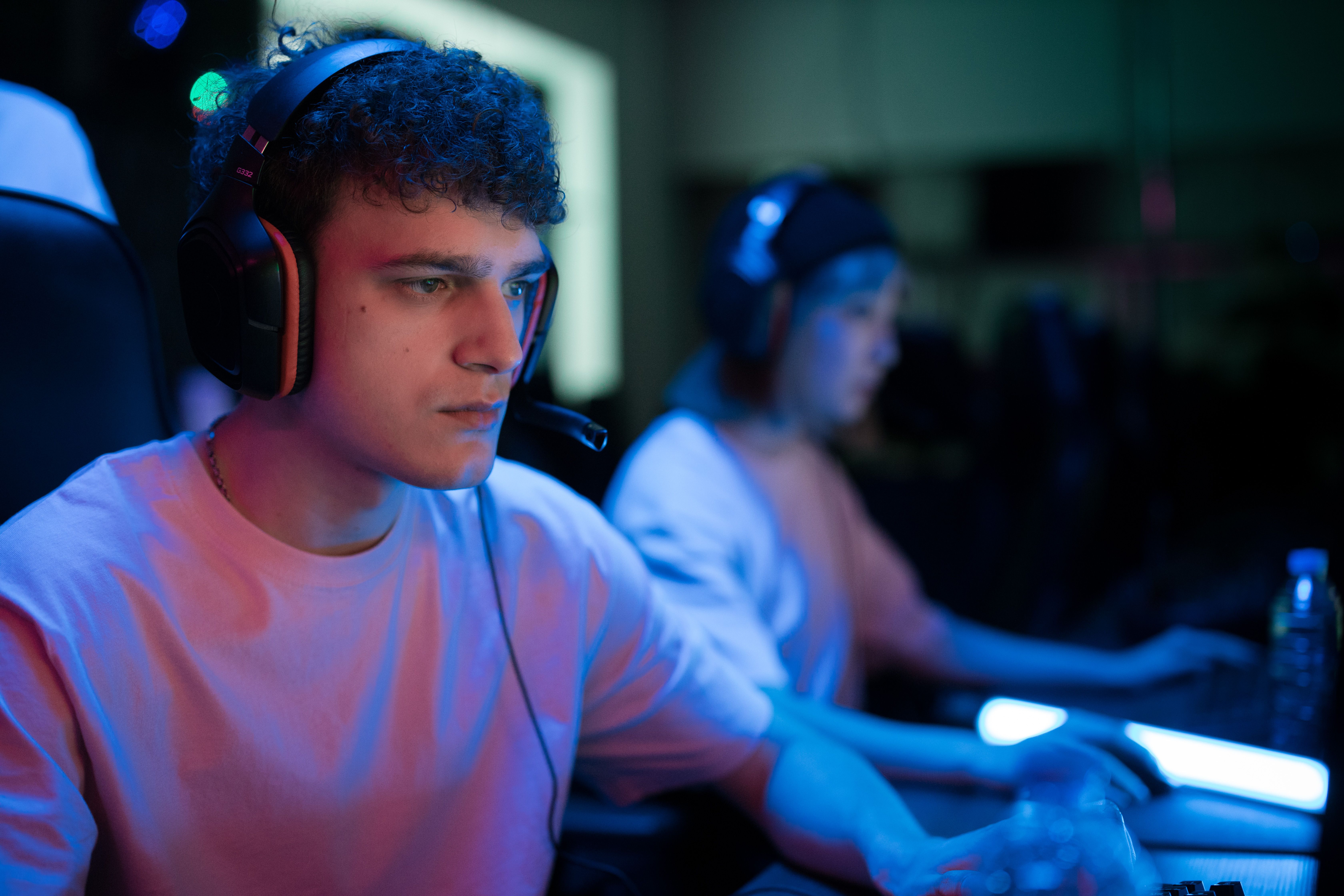 Focused gamer wearing headphones, engaged in playing a controversial PS2 game. Focused gamer wearing headphones, engaged in playing a controversial PS2 game.