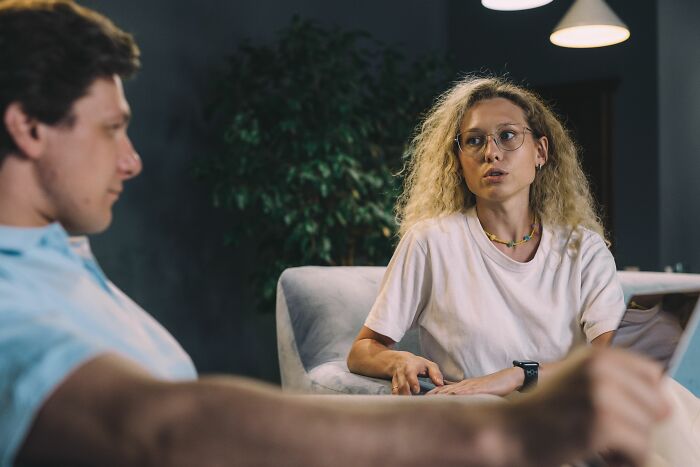 Woman discussing microaggressions with a man in a serious living room setting