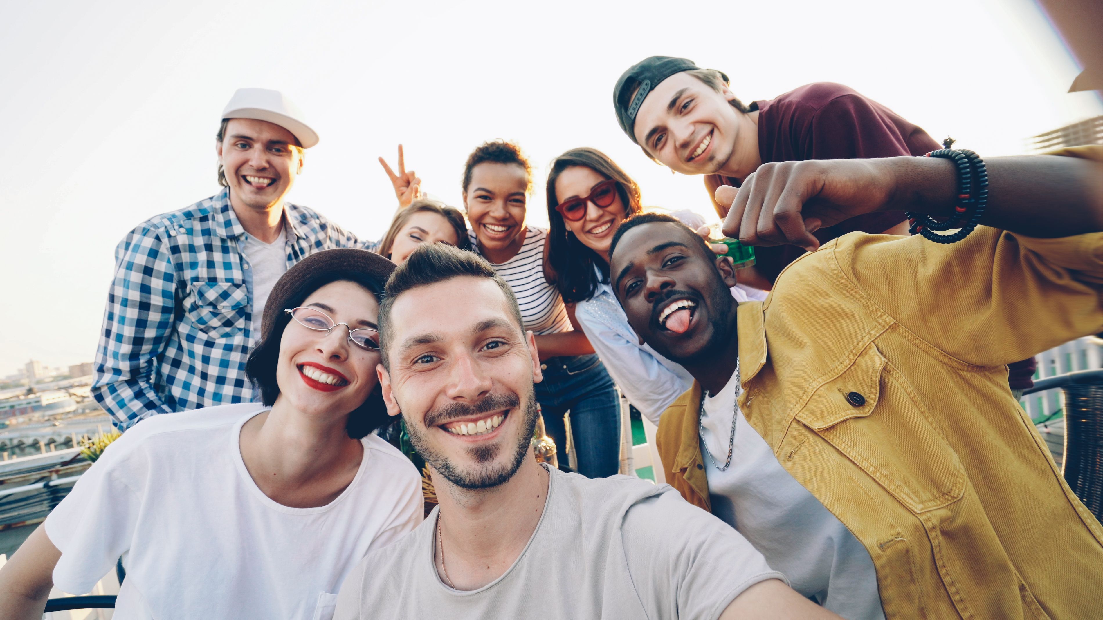 A happy friend group taking a group selfie together outdoors before pregnancy trip drama occurred.