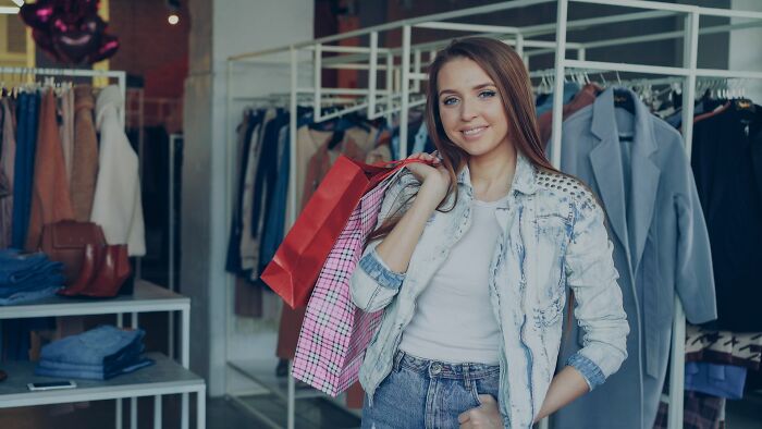 A happy young woman shopping for clothes, representing moving on after deciding to walked away from marriage.