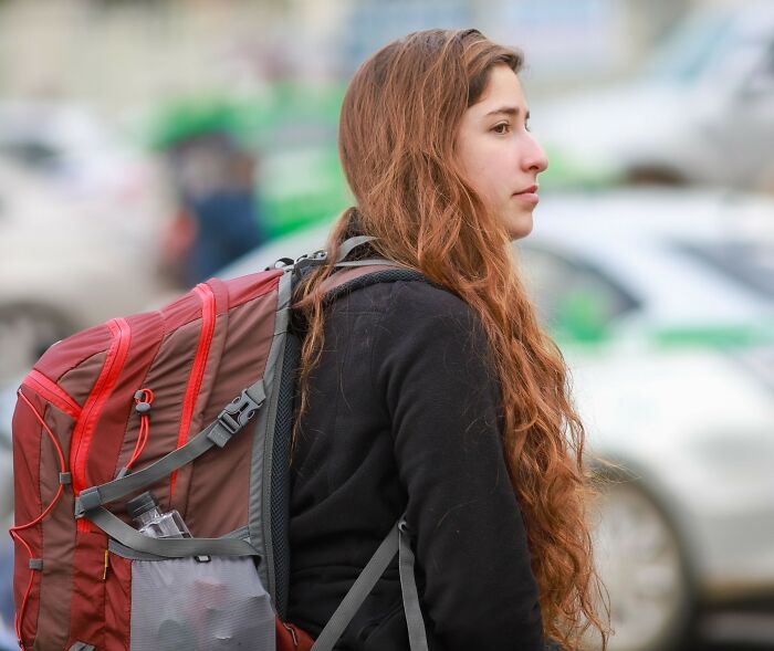 A young woman carrying a backpack looking concerned as her gut feeling kicked in.