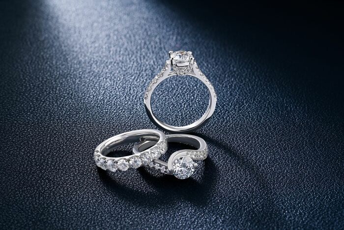 Sparkling diamond engagement rings displayed on dark surface, representing boycotted companies.