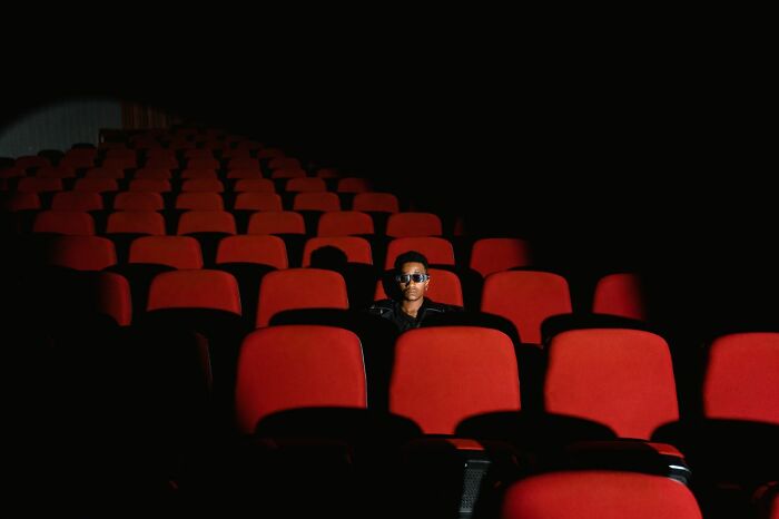 A person wearing 3D glasses sitting alone in a movie theater highlighting clever life tricks