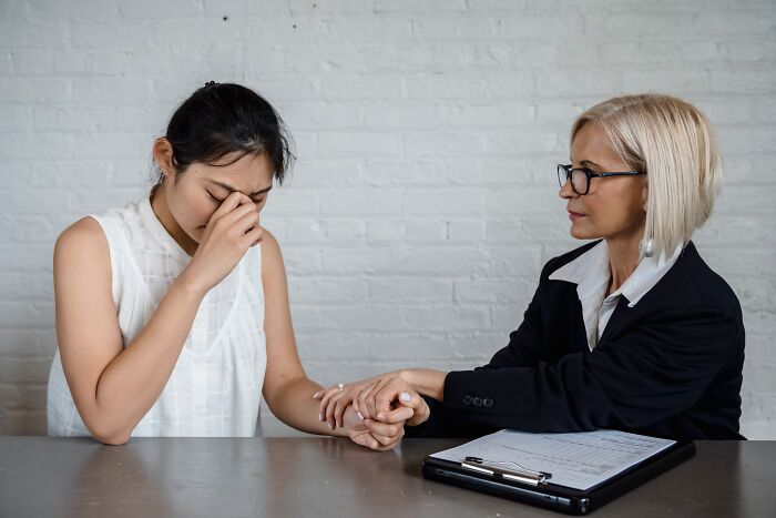 A professional comforting an upset client in an office setting, building or regaining trust.