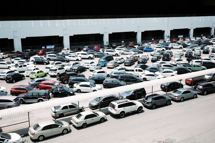 An aerial view of a crowded parking lot packed with cars, illustrating urban life tricks for finding parking spaces.