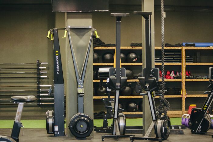 Interior of a gym with exercise equipment, including Concept 2 rowing machines. Unethical Life Pro Tips.