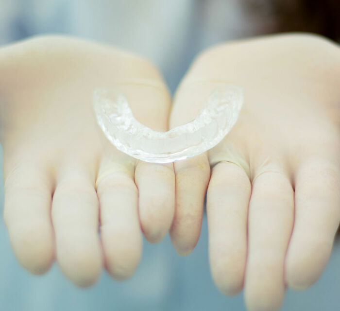 Hands wearing gloves holding dental night guard practical life hacks