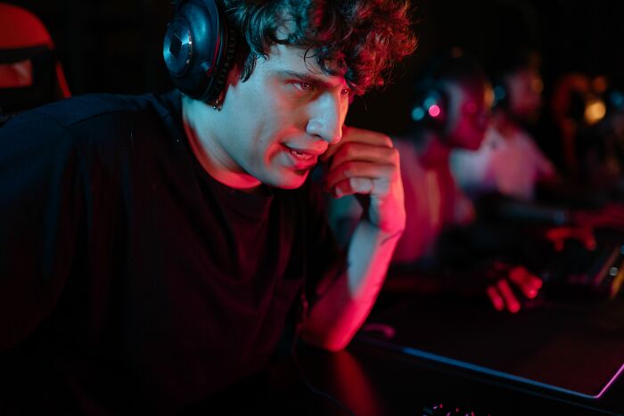 A young man wearing a headset in a dark room keeping personal secrets to himself.