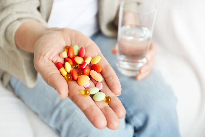 Close-up of hands holding colorful pills and a glass of water, highlighting moments of crisis