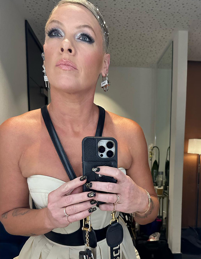 Singer Pink taking a mirror selfie wearing elegant makeup and a white top