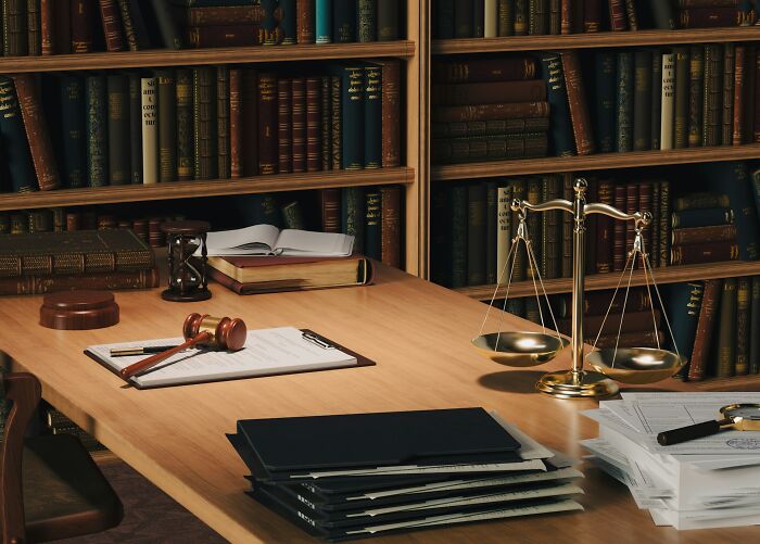 Law office desk with gavel, scales of justice, and books, illustrating legal infidelity stories.