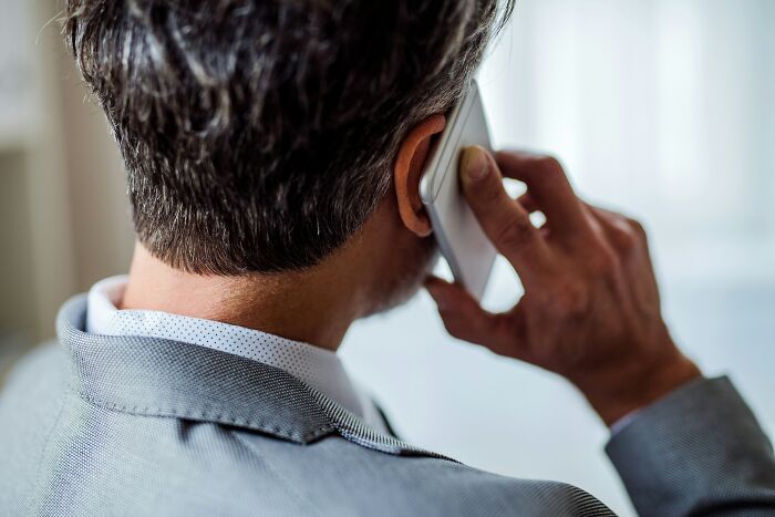 Close up back view of a man talking on his smartphone, demonstrating positive masculinity