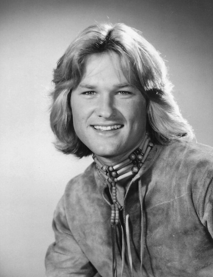 Vintage headshot of Kurt Russell smiling, reflecting positive masculinity and compassion