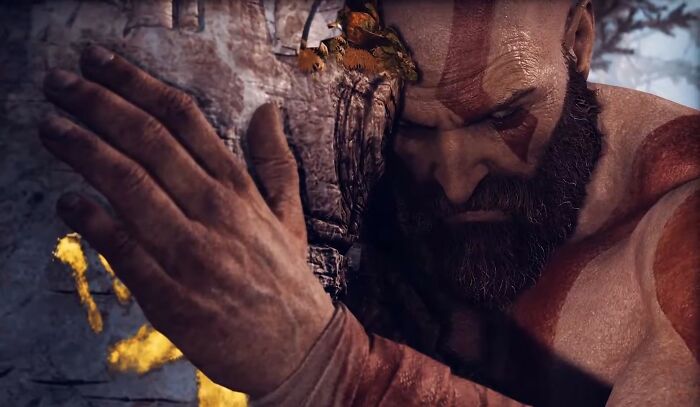 Character Kratos showing gentle emotion, expressing positive masculinity in a quiet moment.