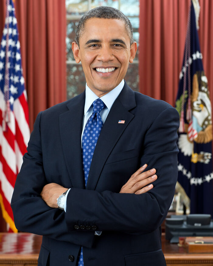 Barack Obama smiling in a suit, exemplifying positive masculinity in leadership.