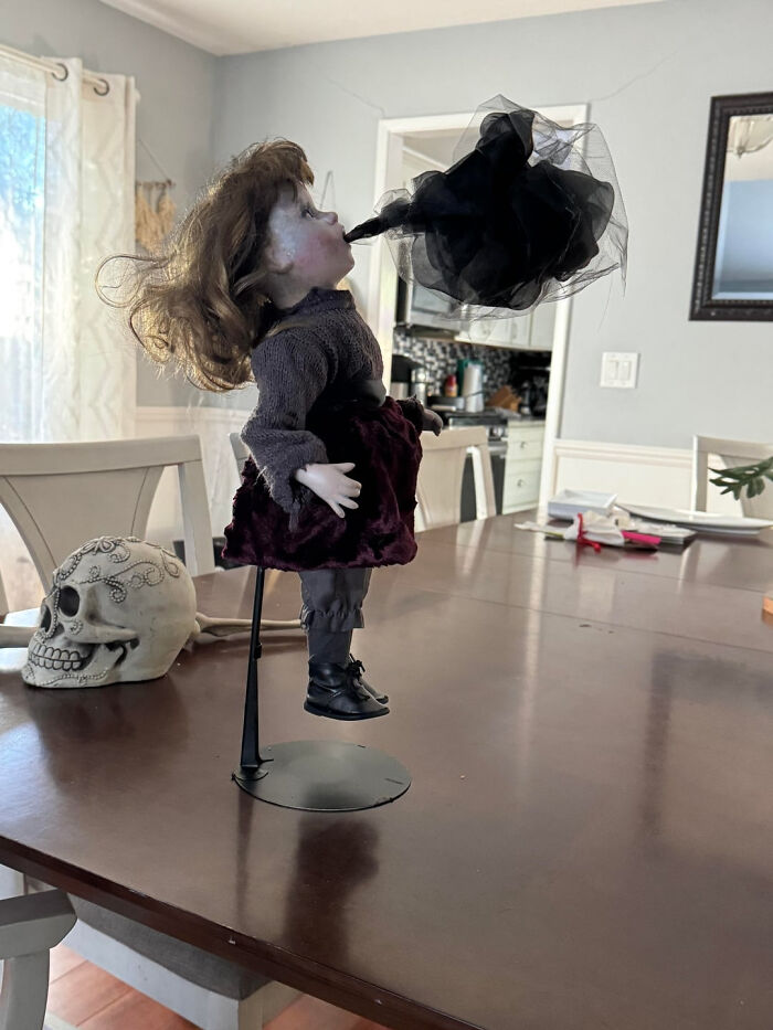 Creepy doll figure standing on a table, perfect for Halloween home decor.