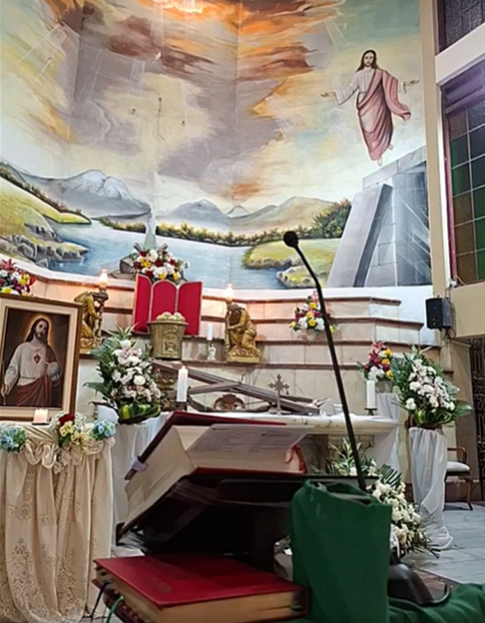 Church altar with religious books and mural after crucifix accident
