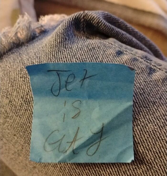 Found paper note with handwritten text reading Jer is cuty attached to blue denim fabric.