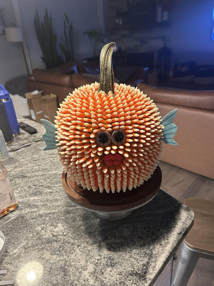 Creative Halloween pumpkin decorated with candy corn to look like a pufferfish.
