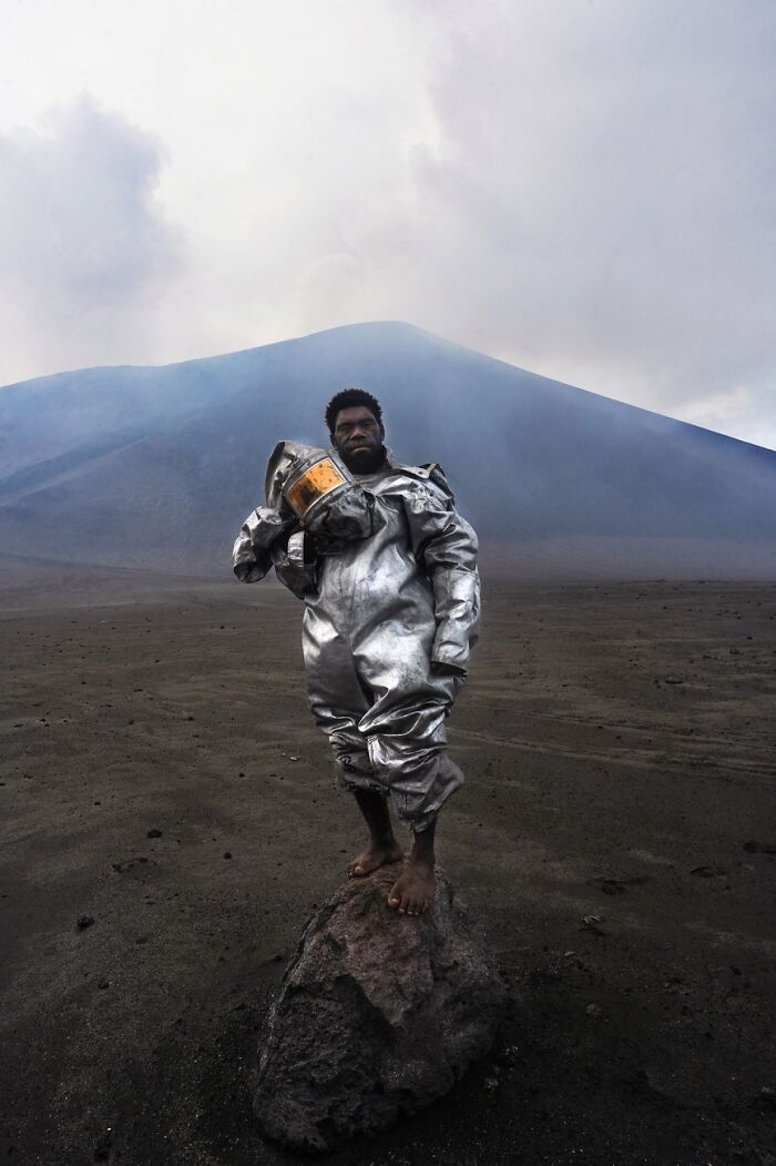 Man in protective suit standing on volcanic terrain, best pics Siena International Photo Awards 2026