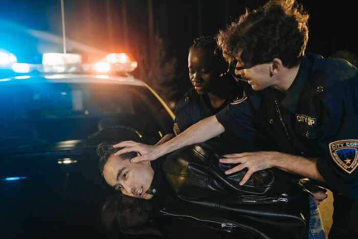 Police officers arresting a suspect at night, depicting someone who got fired during their first week