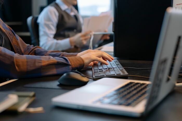 Office worker typing on a computer keyboard who might get fired before their first week is over