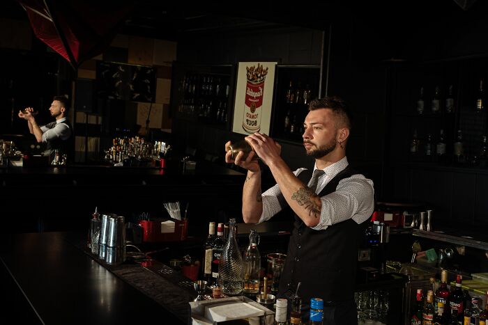 Bartender shaking a cocktail at a bar, related to people who get fired quickly