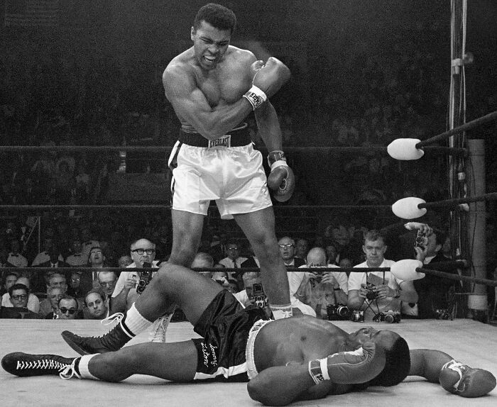 Rare historical photo of boxer celebrating victory over opponent in ring