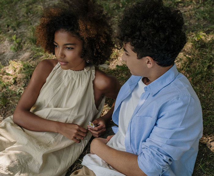 A young boy and girl sitting together in a grassy field. A young boy and girl sitting together in a grassy field.