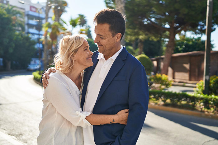 An affectionate couple smiling at each other on a sunny street. An affectionate couple smiling at each other on a sunny street.