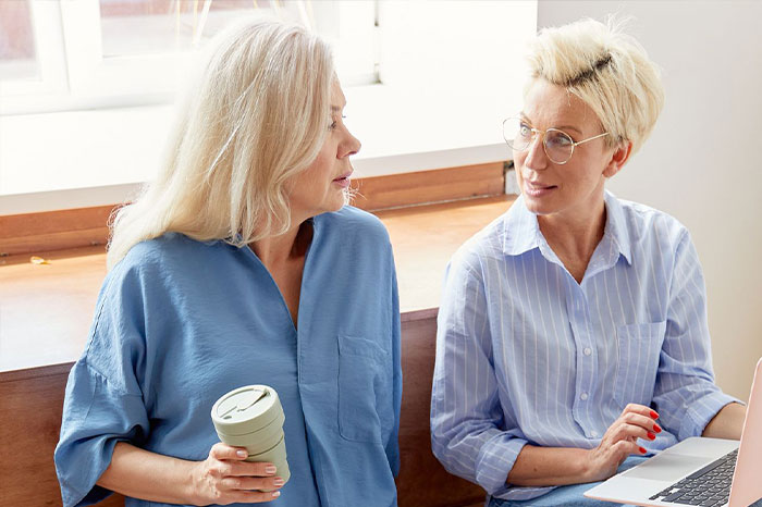 Two adult women having a serious, concerned conversation over a laptop, relating to a sudden breakup. Two adult women having a serious, concerned conversation over a laptop, relating to a sudden breakup.
