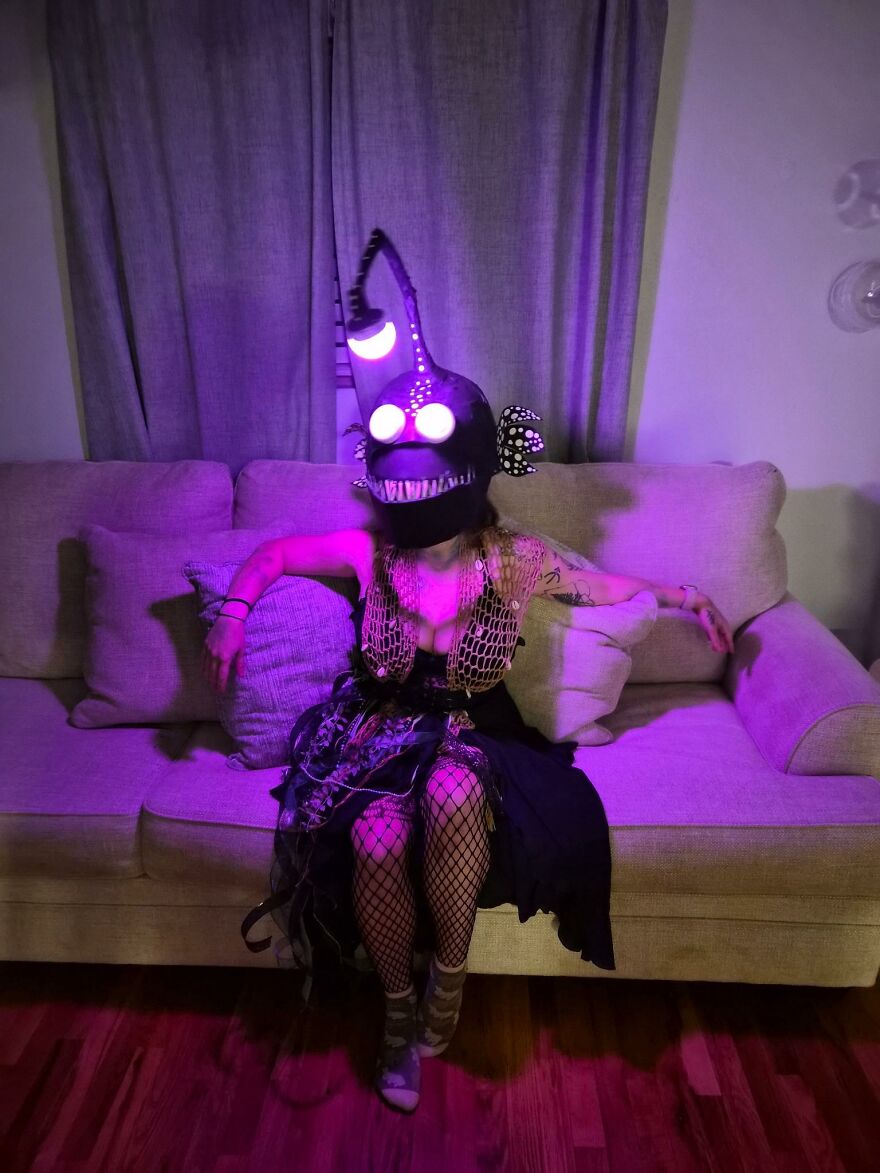 Person wearing a glowing anglerfish headpiece sitting on a couch for creative Halloween costume ideas.