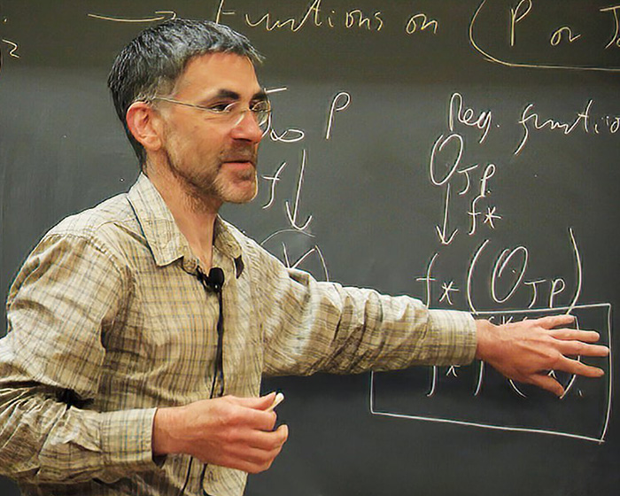 A UC Berkeley professor teaching at a chalkboard filled with complex math formulas.
