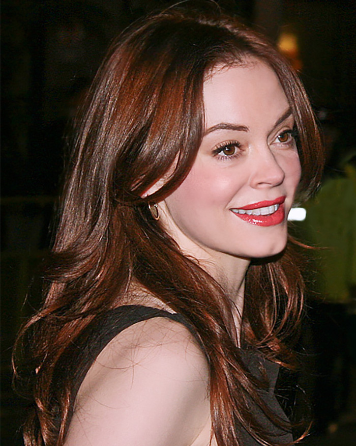 Close-up of woman with red hair smiling in nightlife setting