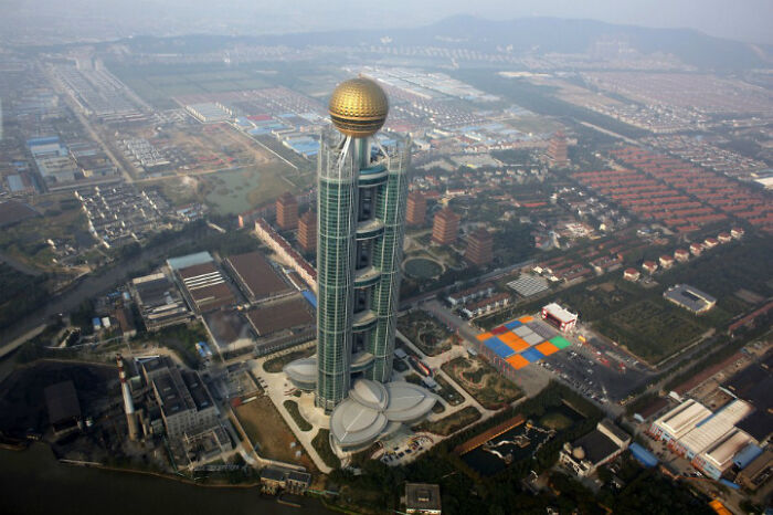 Aerial view of unique tower with golden sphere on top and surrounding complex