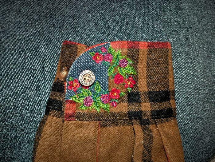 Detailed floral embroidery on a plaid cuff, showing how creativity can save money through mending.