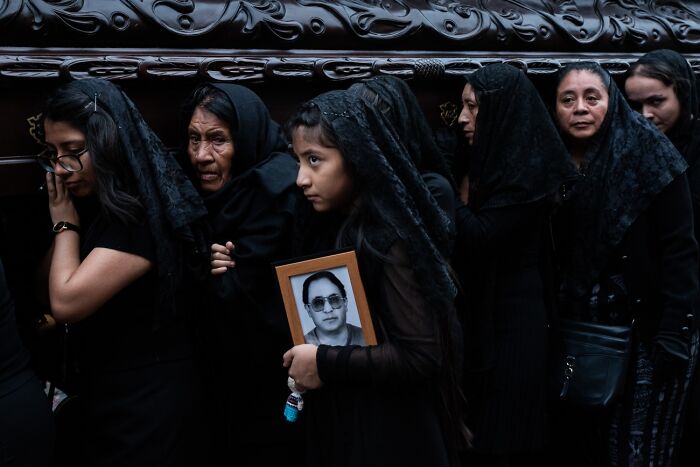 Women in black veils at a funeral holding framed photo, best pics Siena International Photo Awards 2026