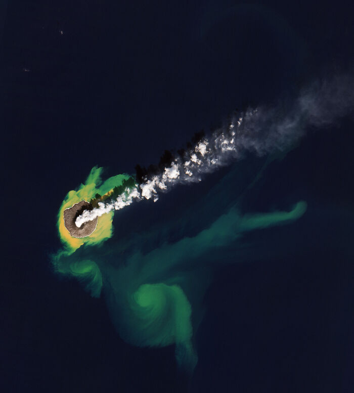 Surreal satellite photos showing an erupting volcanic island spewing ash into dark ocean waters.