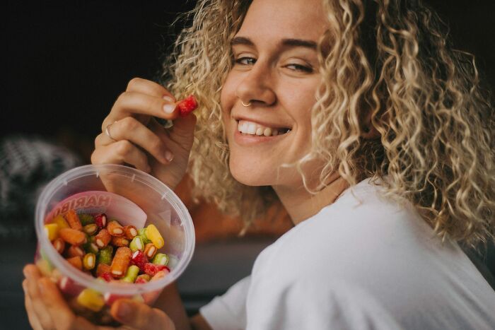 A happy passenger enjoying a cup of colorful candy on flights.