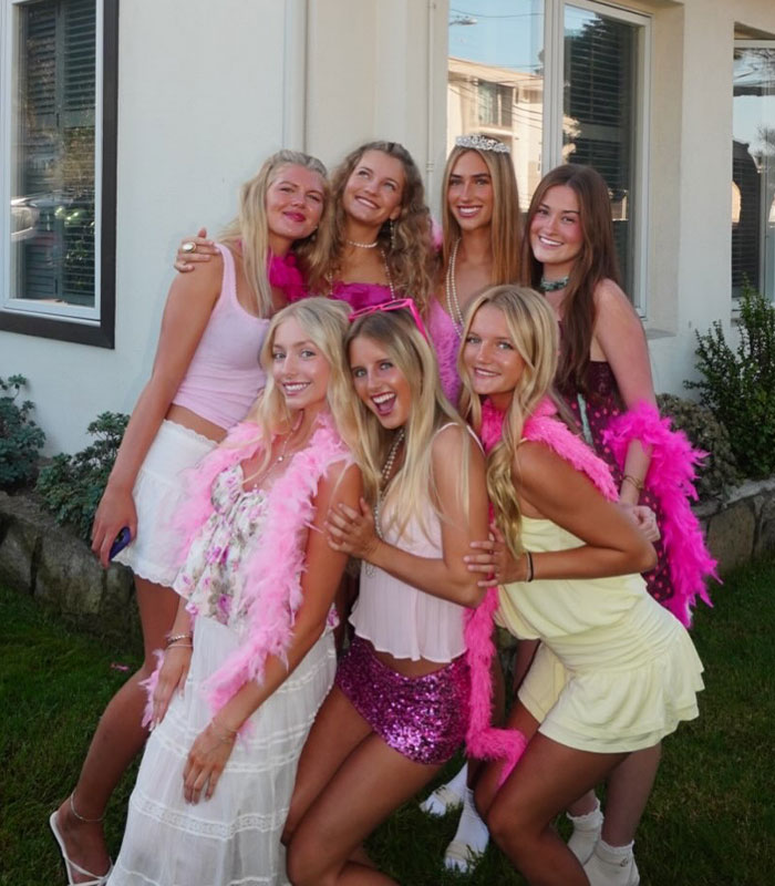 Group of women in pink outfits celebrating sorority scandal