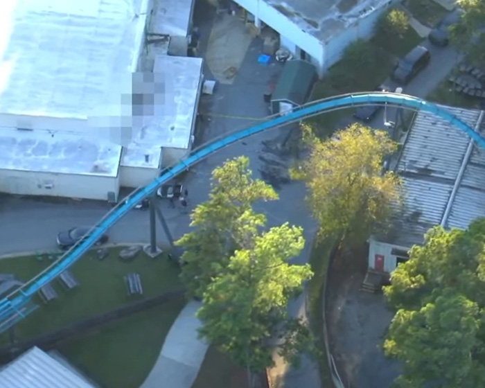 Aerial view of a blue Six Flags roller coaster track near park buildings. Aerial view of a blue Six Flags roller coaster track near park buildings.
