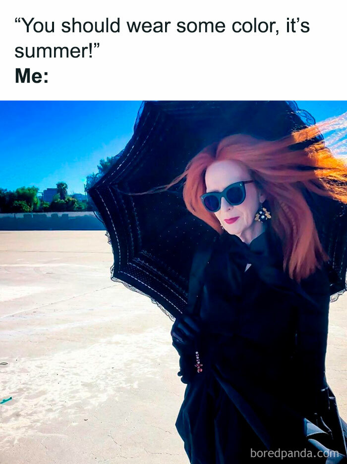 Spooky season meme showing Myrtle Snow in a black dress with an umbrella under the bright summer sun.