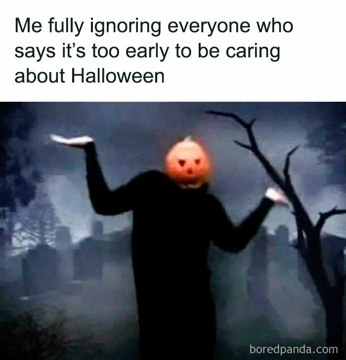 Spooky season meme of a person wearing a pumpkin head shrugging in a graveyard.