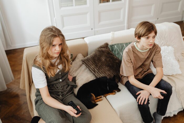 Two young kids holding remotes on a couch, representing millennials watching the classic Stacy's Mom video. Two young kids holding remotes on a couch, representing millennials watching the classic Stacy's Mom video.