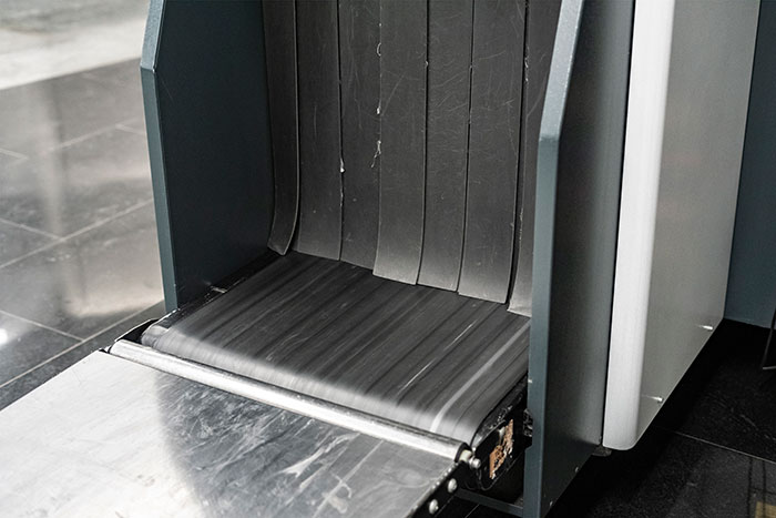 Airport baggage scanner conveyor belt where TSA agents screen travelers luggage