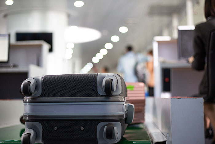 A close-up of a suitcase on an airport conveyor belt, symbolizing luggage check for travelers stopped by TSA