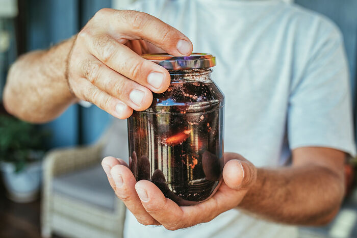 Strong hands of a man opening a tight glass jar, illustrating what it is like living with guys.