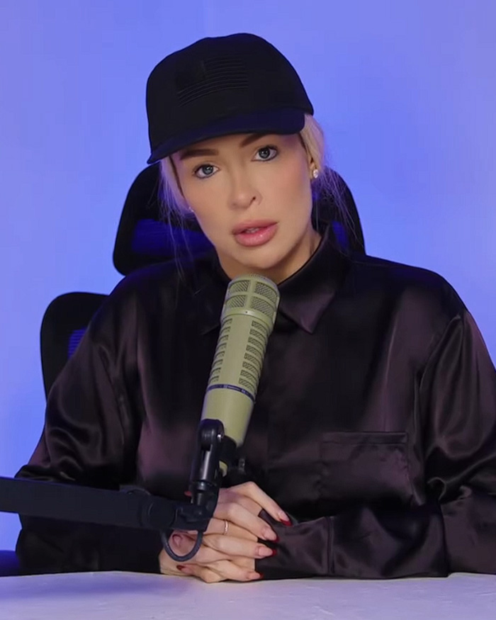 Influencer wearing a black cap and shirt as an Erika Kirk parody Halloween costume.