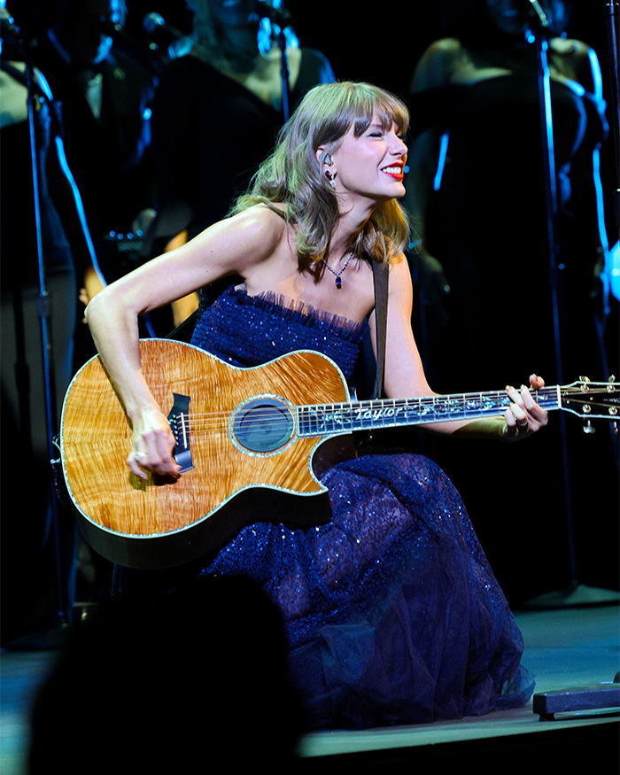 Taylor Swift performing live with acoustic guitar in blue dress on stage Taylor Swift performing live with acoustic guitar in blue dress on stage